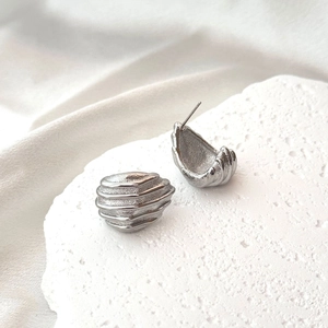 Minimalist silver geometric earrings with a refined striped texture and shell shape