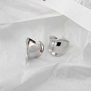 Close-up of elegant silver pleated wide C-shape earrings with a polished mirror finish
