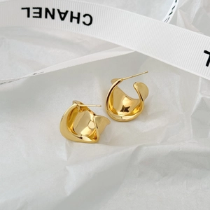 Detailed view of elegant gold pleated irregular metal stud earrings on silk ribbon