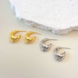 Three-layer twisted metal hoop earrings in polished gold and silver finishes