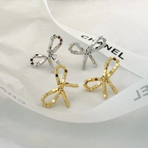 Detailed view of silver and gold bow stud earrings crafted with delicate metal beads