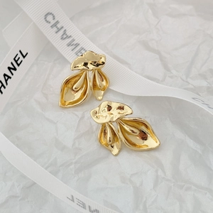 Detail shot of golden abstract irregular petal earrings on a minimalist white background