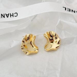 Irregular textured gold stud earrings with a glossy finish and geometric wavy design