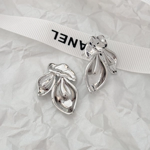 Detail of silver leaf earrings with stacked petals on a white ribbon background
