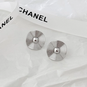 Macro detail of silver round textured stud earrings with concentric circle patterns