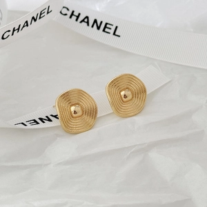 Elegant gold textured irregular oval stud earrings on white silk ribbon background