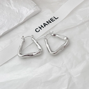 Macro shot of wavy geometric triangle metal hoop earrings with high-polish silver finish