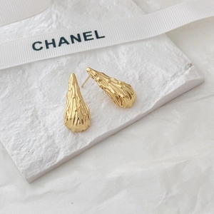 Macro shot of 18K gold water drop earrings with unique molten lava texture on stone