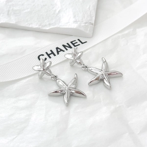 Détail de boucles d'oreilles double étoile de mer argentées avec finition métallique lisse