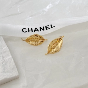 Minimalist gold leaf earrings with textured veins shown on elegant white marble background