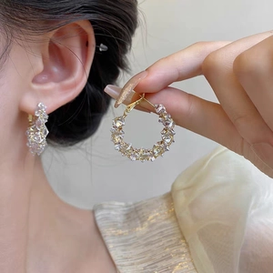 Élégantes créoles dorées ornées de cristaux de zircon portées par un mannequin