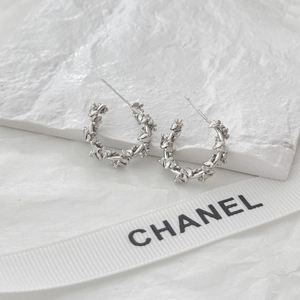 Irregular double C-shaped silver earrings with minimalist textured surface on stone