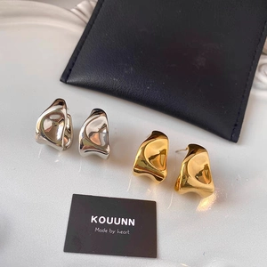 Irregular liquid metal geometric earrings in gold and silver finish on display