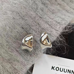 Detailed macro view of S925 silver earrings with irregular geometric shapes and high polish