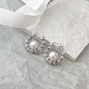 Elegant silver textured metal hoop earrings with round white pearl in refined still life