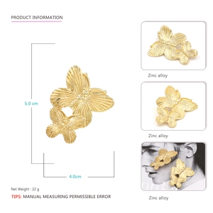 Detail of oversized gold-tone butterfly earrings made from zinc alloy with precise sizing