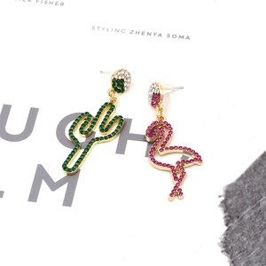 Detail view of colorful asymmetric cactus and flamingo earrings with embedded rhinestones