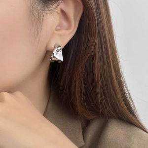 Irregular geometric liquid metal silver earrings worn by model for minimal style