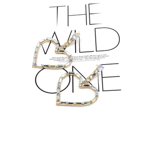 Macro detail of heart hoop earrings with rainbow rhinestones on a fashion magazine