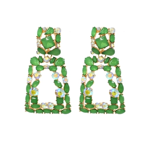 Macro detail of geometric drop earrings with emerald green crystals and AB rhinestones