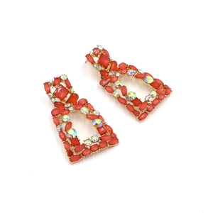 Detail of vintage geometric earrings with red stones and rainbow AB crystals on gold base