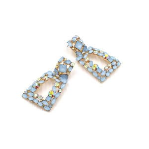 Close-up of vintage geometric gold earrings with light blue stones and AB rhinestones