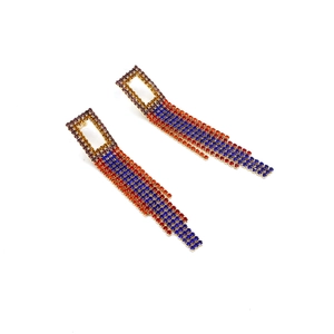 Close-up of long tassel earrings with vibrant blue and red crystal rhinestone chains