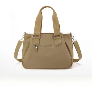 Rear view of khaki nylon crossbody bag featuring back zipper pocket and silver hardware