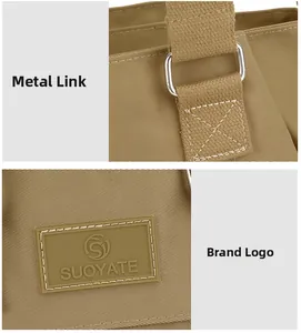 Close-up of the silver metal hardware and the rubberized brand logo on the nylon bag