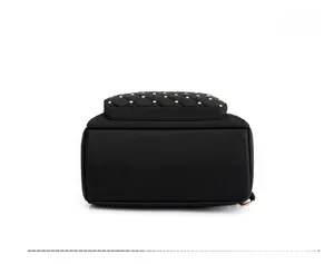 Detailed bottom view of a quilted black backpack with golden studs and reinforced seams