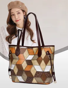 Close-up of geometric patchwork tote bag with crocodile pattern and brown handles