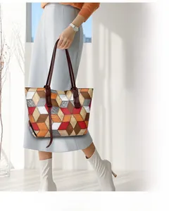 Dettaglio della borsa tote geometrica 3D con segmenti stampati e tracolle lunghe marroni