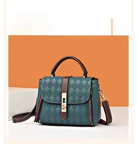Détail du sac à main vert foncé avec gaufrage en losanges et fermoir en métal doré