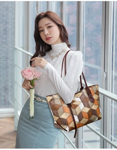 Dettaglio della borsa tote capiente con motivi geometrici 3D e manici in pelle marrone