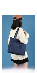 Vue latérale du grand sac à bandoulière en nylon bleu marine porté par un mannequin