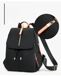 Detail of waterproof Oxford cloth backpack featuring long reddish-brown leather zipper pulls
