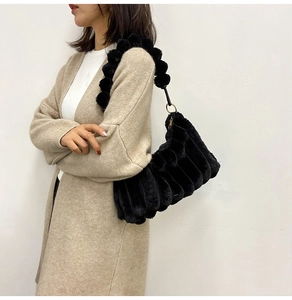 Detail of black faux fur shoulder bag with ruffled texture and plush strap elements