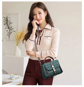 Sac à bandoulière matelassé vert foncé avec poignée marron porté par un mannequin chic