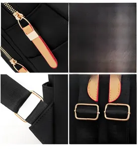 Detail of gold-tone metal hardware and leather zippers on black Oxford fabric backpack