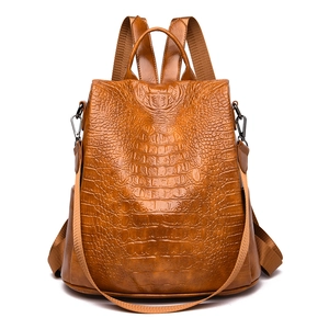 Detailed front view of brown crocodile texture leather backpack with metallic accents
