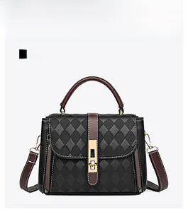 Vue de face du sac à main matelassé noir avec poignées marron et boucle dorée élégante