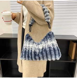 Detail of blue and white plush shoulder bag with fluffy wave texture and metal ring
