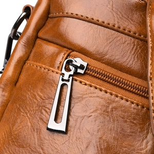 Macro shot of brown faux leather texture with silver zipper and precise stitching details