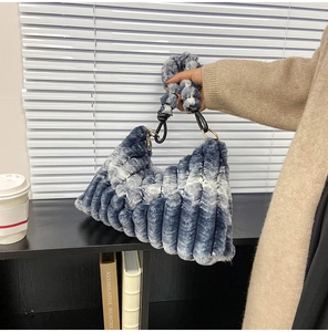 Detail of blue and white gradient plush handbag featuring vertical striped texture