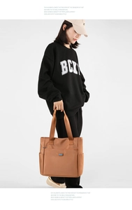 Vue détaillée du grand sac cabas en nylon marron avec poche zippée et larges lanières