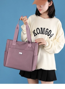Vue détaillée du grand sac cabas en nylon lilas avec larges anses et poches latérales pratiques