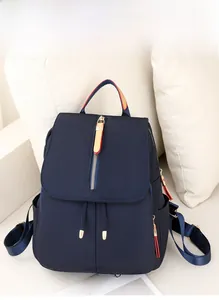 Close-up of navy blue oxford backpack with gold zippers and tricolor webbing handle