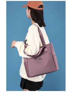 Vue détaillée du sac fourre-tout en nylon violet avec poche latérale et logo