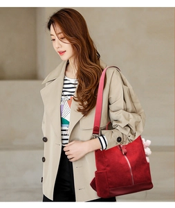 Detail of dark red corduroy backpack showing textured fabric and adjustable shoulder straps
