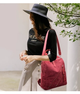Detail of red corduroy backpack showing thick fabric texture and pink woven straps